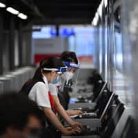 Airline employees work at Narita International Airport in Chiba Prefecture. | AFP-JIJI