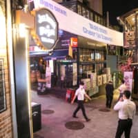 Pedestrians walk through the Itaewon district of Seoul on Friday.  | BLOOMBERG 