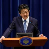 Prime Minister Shinzo Abe speaks at a news conference in Tokyo on June 18. | POOL / VIA REUTERS