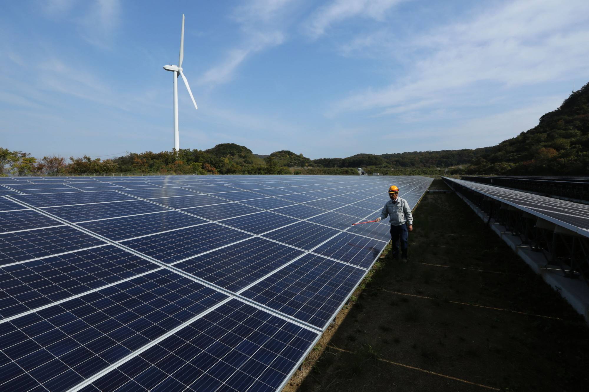 An engineer inspects solar panels at Banpu Power's solar plant in Awaji, Hyogo Prefecture. | BLOOMBERG