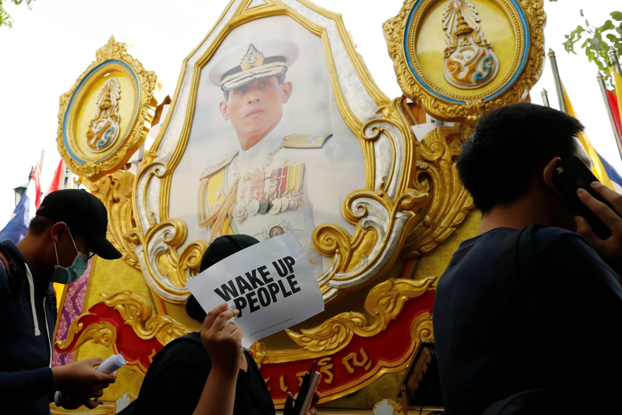 Pro-democracy protesters walk past a picture of Thai King Maha Vajiralongkorn during a rally to demand that the government resign, dissolve the parliament and to hold new elections under a revised constitution, near the Democracy Monument in Bangkok on Aug. 16. | REUTERS