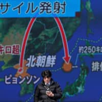 A man walks past a street monitor showing a news report about a North Korean missile launch in Tokyo in November 2017. | REUTERS