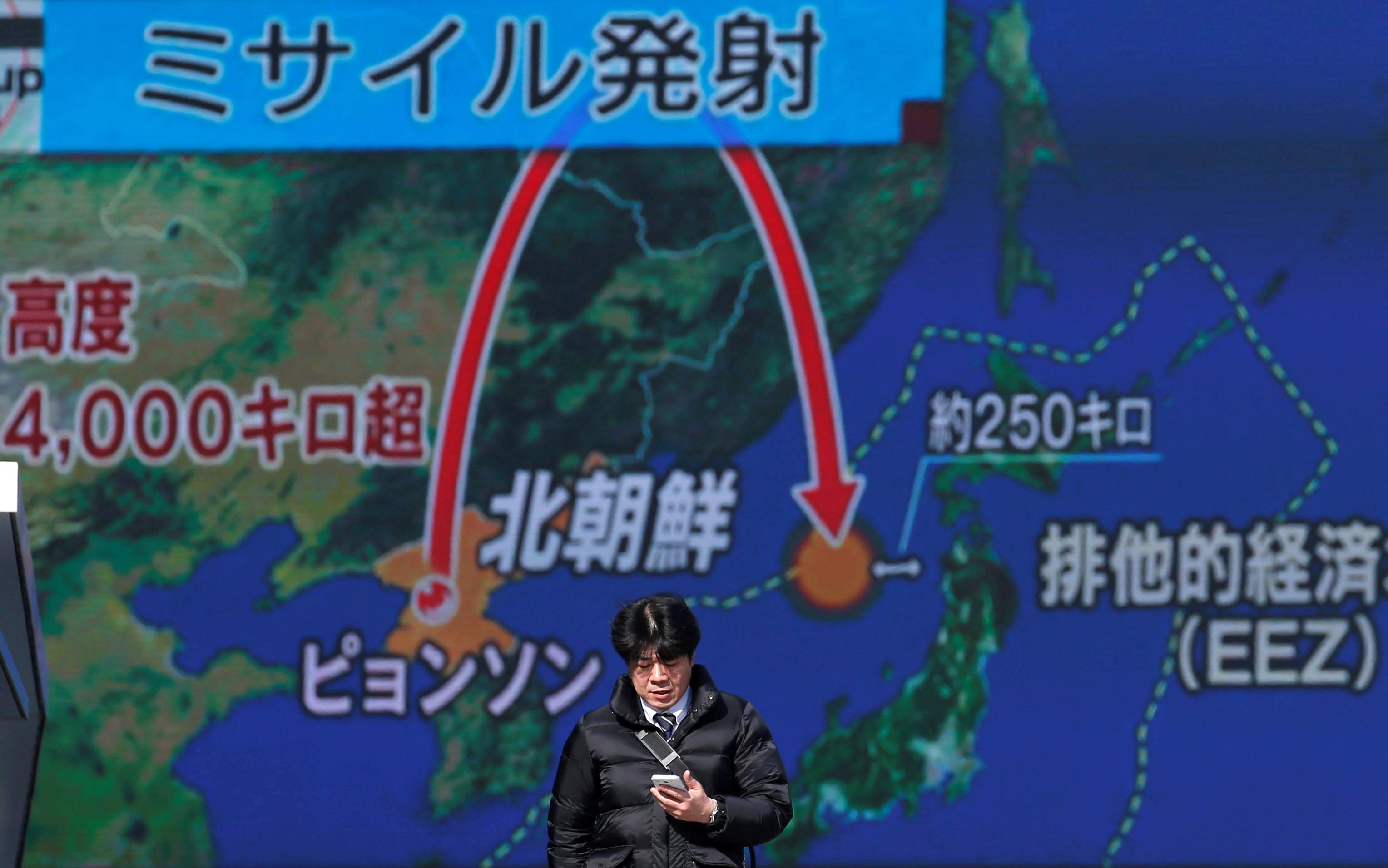 A man walks past a street monitor showing a news report about a North Korean missile launch in Tokyo in November 2017. | REUTERS