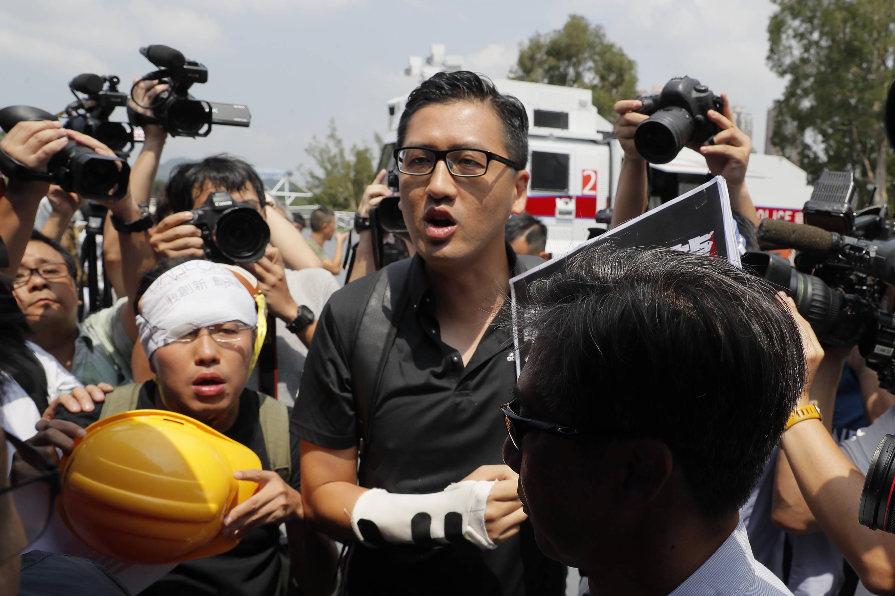 Pro-democracy lawmaker Lam Cheuk-ting argues with a pro-Beijing lawmaker during a demonstration of an anti-riot vehicle equipped with a water cannon in August last year. | AP