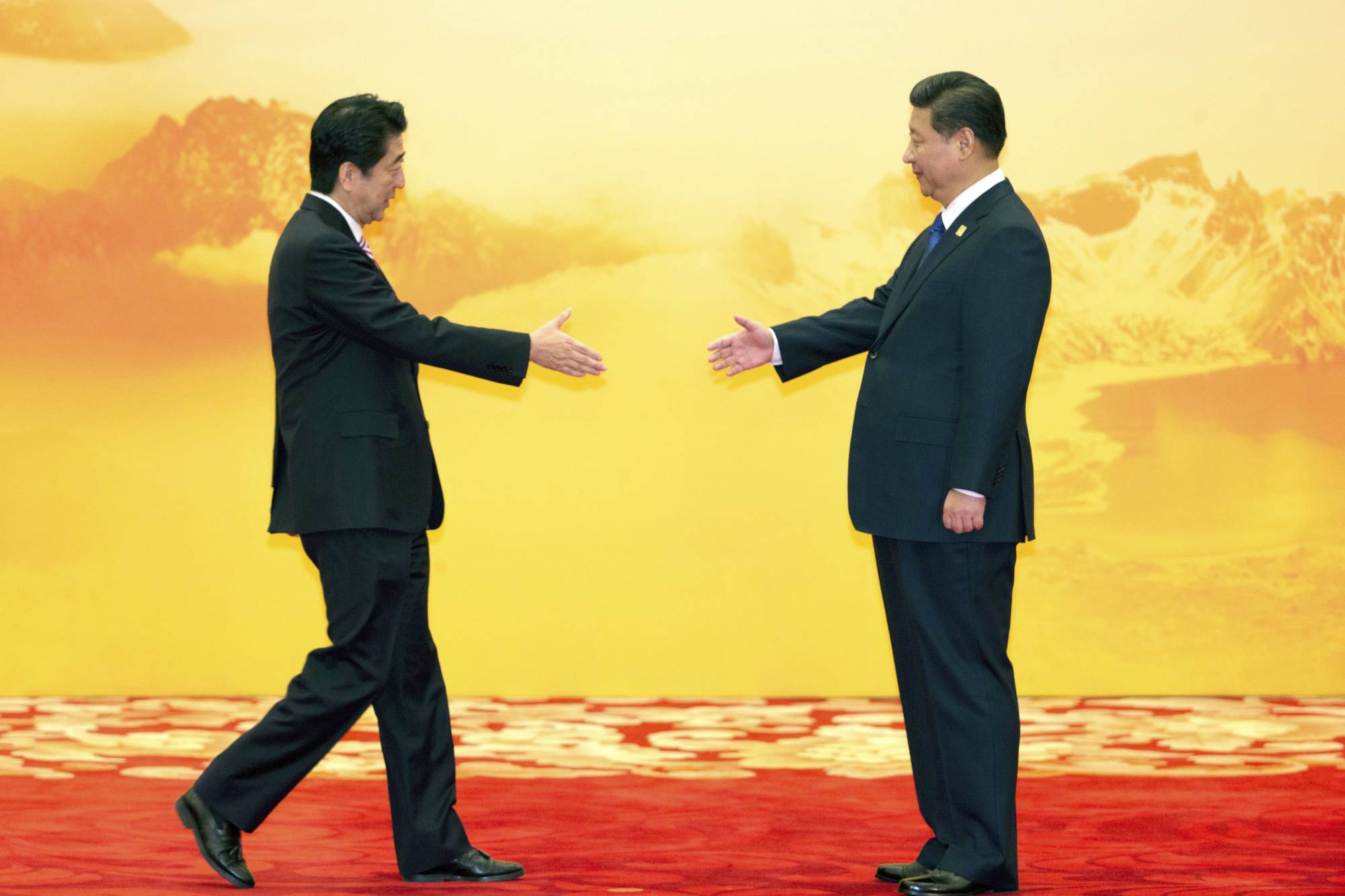 Prime Minister Shinzo Abe greets Chinese President Xi Jinping during an Asia-Pacific Economic Cooperation meeting in Beijing in November 2014. | AP