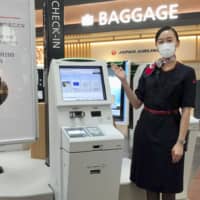 Japan Airlines Co. is testing contactless self-service check-in machines with motion sensors that let customers avoid picking up the coronavirus.  | JAPAN AIRLINES CO. / VIA KYODO