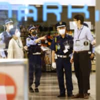 Police investigate the crime scene at a shopping mall in Fukuoka on Friday night. | KYODO