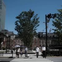 Pedestrians cross a street in the Marunouchi District of Tokyo on Friday. | BLOOMBERG