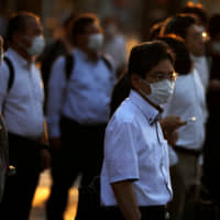 Office workers head home at sunset amid the COVID-19 outbreak in Tokyo. | REUTERS