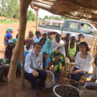 Fuji Oil Holdings Inc. employees pose with local farmers in Burkina Faso in July 2018. Fuji Oil Group is conducting research on sustainable procurement of soybeans, as well as improving the health of area residents through development of soybean meat substitutes. | COURTESY OF  FUJI OIL HOLDINGS INC.