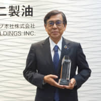 Fuji Oil Holdings Inc.’s President Hiroshi Shimizu holds the Grand Prize trophy in the ESG category at the company in Osaka. | FUJI OIL HOLDINGS INC.