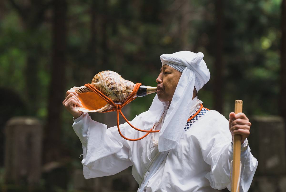 A mountain ascetic hermit blowe on a conch shell in Yamagata Prefecture. | COURTESY OF DEREK YAMASHITA 