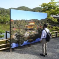 A large photo panel was set up at Kinkakuji temple in Kyoto on Tuesday, as renovation work that started the same day will prevent visitors from viewing the famed golden pavilion. | KYODO