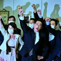 LDP Policy Research Council Chairman Fumio Kishida (center) raises his fist in the air with his faction members after announcing his candidacy for the LDP leadership during a meeting in Tokyo on Tuesday. | AFP