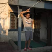 Yasir Reshi at his residence, while an Indian paramilitary soldier stood by as protection, in Srinagar, India | SHOWKAT NANDA/THE NEW YORK TIMES