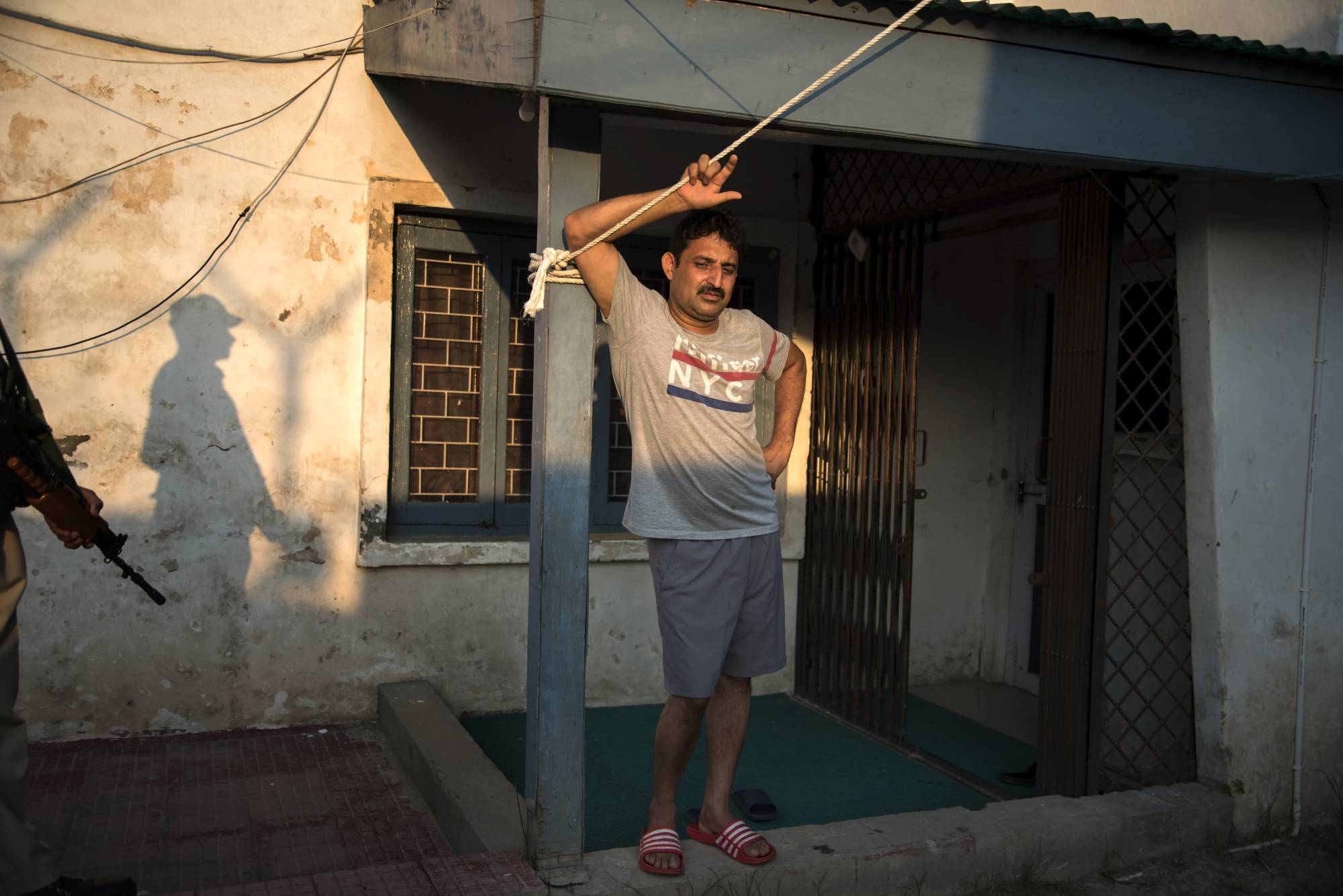 Yasir Reshi at his residence, while an Indian paramilitary soldier stood by as protection, in Srinagar, India | SHOWKAT NANDA/THE NEW YORK TIMES