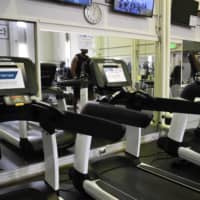 Some treadmills have been marked as unavailable at the Samurai Fitness Center, where hand sanitizers and reminders of mask-wearing policies are omnipresent. | TOMOHIRO OSAKI
