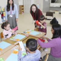 Teachers and children engage in a Japanese language class for overseas residents in Kani, Gifu Prefecture, in February. | KYODO