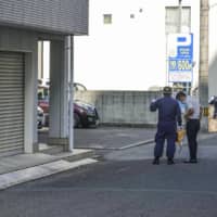 Kagawa police officers on Friday investigate a site in Takamatsu where a car had been parked the previous day with two girls inside who were later declared dead. | KYODO