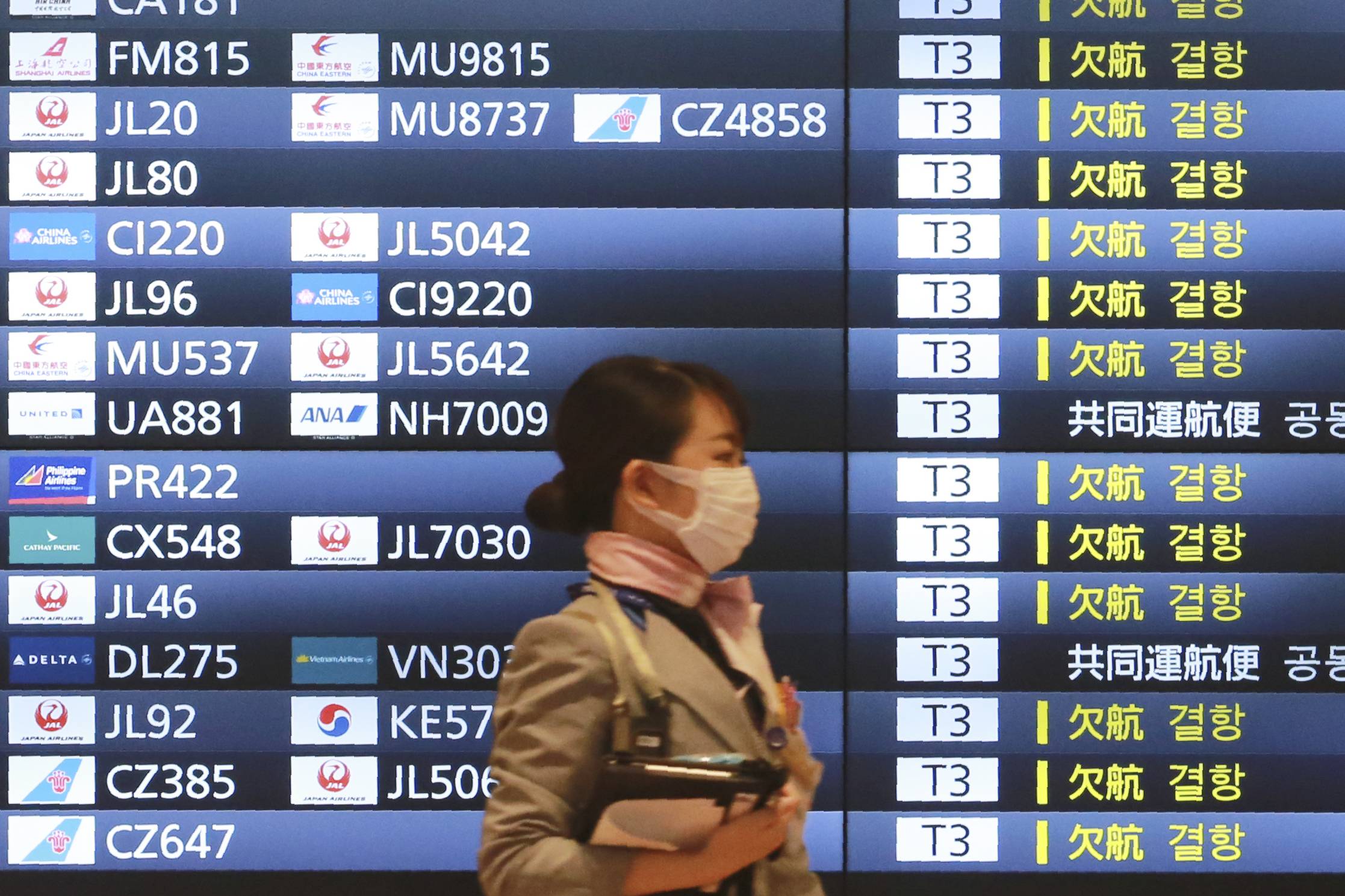 A woman walks through Haneda International Airport in Tokyo. | AP