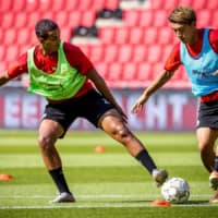 PSV\'s Ritsu Doan (right) vies for the ball with teammate Mohamed Ihatteren during a training session on Aug. 12 in Eindhoven, the Netherlands. | AFP-JIJI