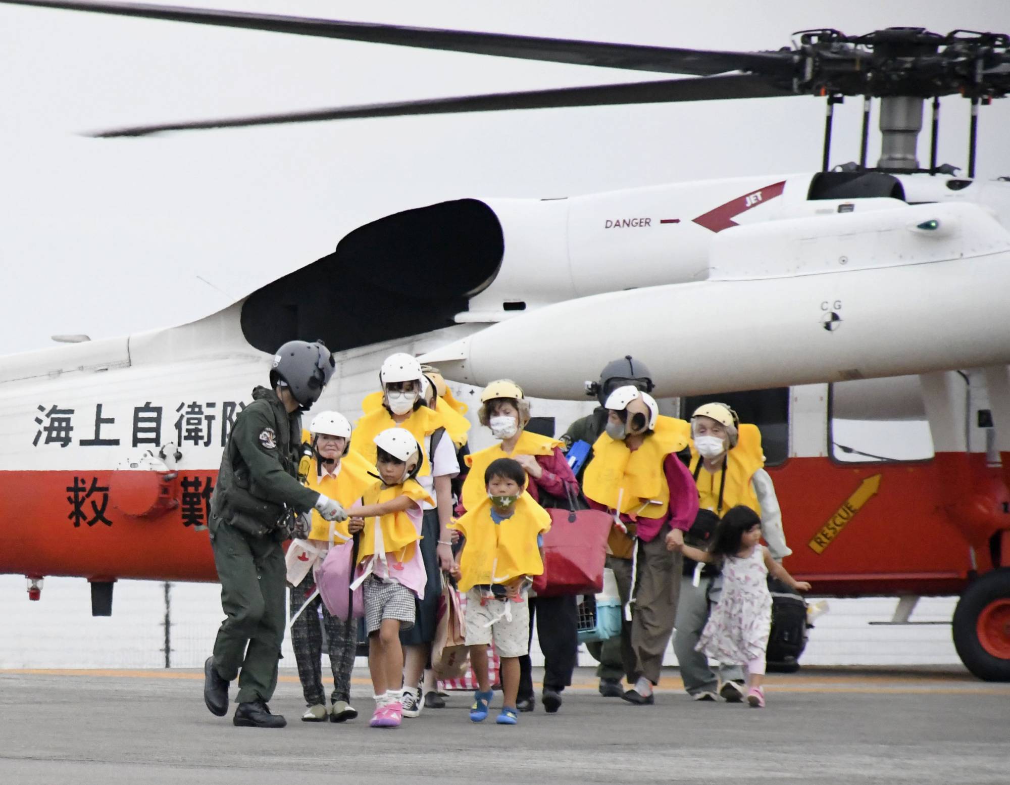 Residents of the village of Toshima, Kagoshima Prefecture, arrive at a heliport in the city of Kagoshima on Friday as they evacuate from the island in preparation for the approaching Typhoon Haishen. | KYODO