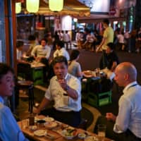 People gather at an \"izakaya\" Japanese-style bar in Tokyo on Friday night. | AFP-JIJI