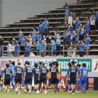Sagan fans greet the players after their win over Yokohama FC on Saturday at Best Amenity Stadium in Tosu, Saga Prefecture. J. League and NPB clubs have been restricted to maximum attendances of 5,000 since professional sports resumed earlier this summer. | KYODO