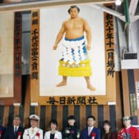 Three-time Olympic women\'s wrestling gold medalist Saori Yoshida (second from right) and others pose under a portrait of former yokozuna Chiyonofuji at JR Ryogoku station in Sumida Ward. | POOL / VIA KYODO