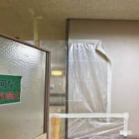 A photo supplied by a source shows the space left between the ceiling and a plastic sheet placed in a hallway at Midori Municipal Hospital in Nagoya to prevent the spread of COVID-19, with tape attaching the sheet to the wall peeling off. | CHUNICHI SHIMBUN
