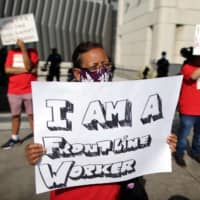 Laid-off airport workers hold a protest to call for the need to extend health care benefits amid the global outbreak of the coronavirus disease at the Tom Bradley International terminal of LAX Airport in Los Angeles on Sept 3.   | REUTERS
