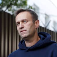 Russian opposition leader Alexei Navalny speaks with journalists after he was released from a detention center in Moscow last August.  | REUTERS 