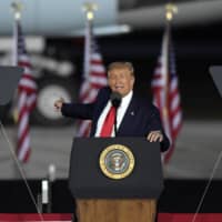 U.S. President Donald Trump speaks during a campaign rally at MBS International Airport in Freeland, Michigan, on Thursday. | AP