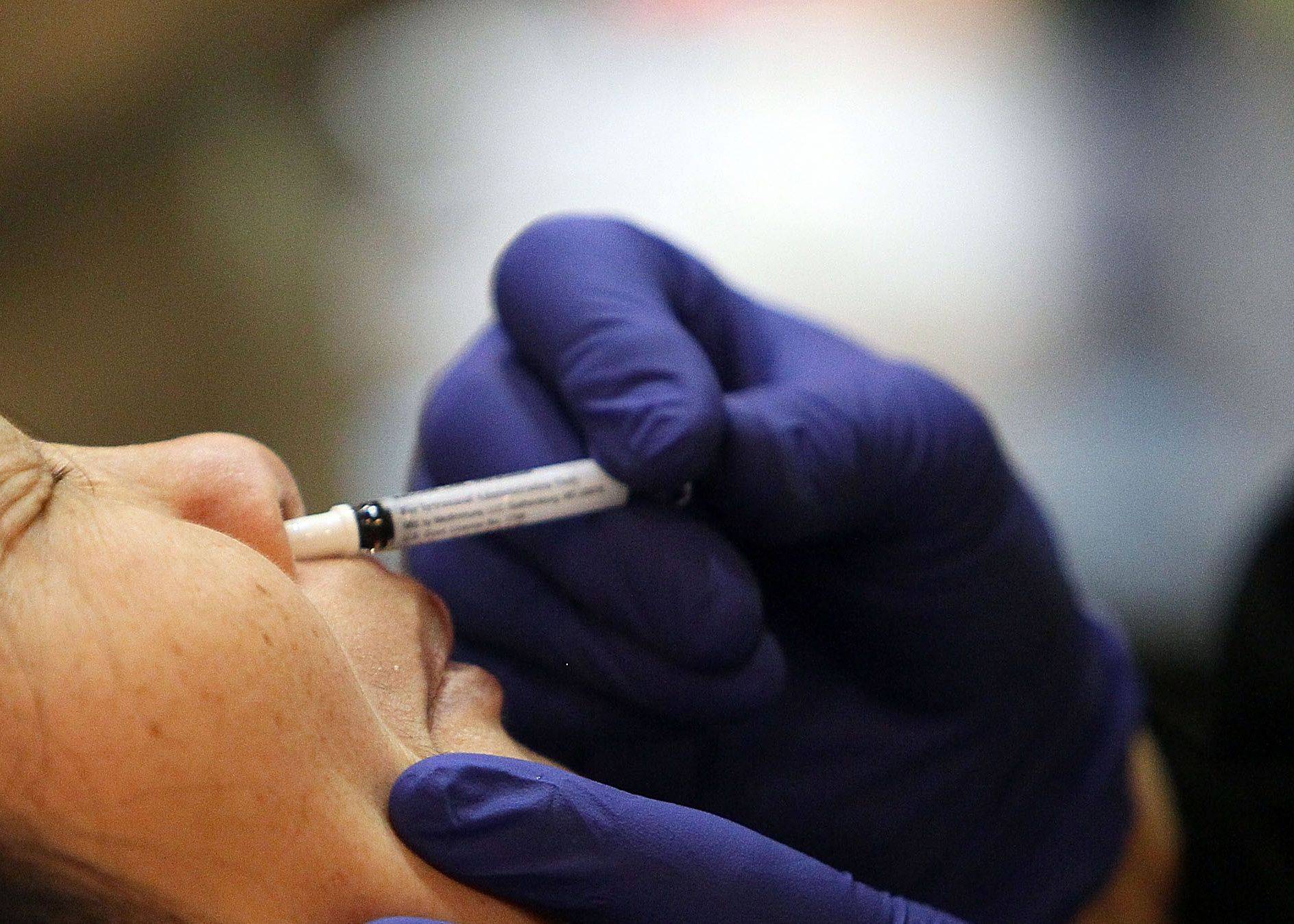 A woman receives an H1N1 flu nasal spray vaccination in San Francisco in 2009. | GETTY IMAGES / VIA BLOOMBERG