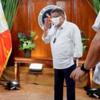 Philippine President Rodrigo Duterte returns a salute to Chinese Defense Minister Wei Fenghe during their meeting at the Malacanang Palace in Manila on Friday. | PRESIDENTIAL PHOTO DIVISION / VIA AFP-JIJI