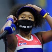 Naomi Osaka adjusts her mask after defeating Jennifer Brady in their U.S. Open semifinal on Thursday in New York. | AP