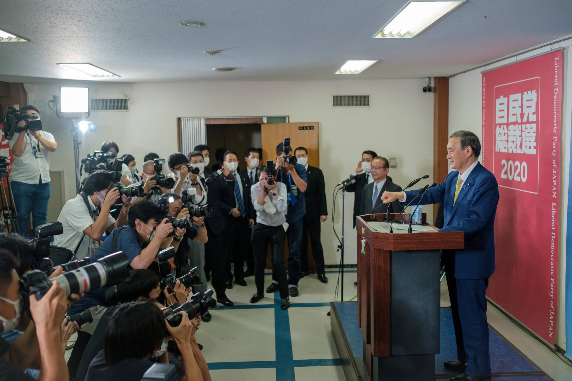 Chief Cabinet Secretary Yoshihide Suga gestures before a news conference at the LDP headquarters in Tokyo on Monday. | Pool / via Reuters