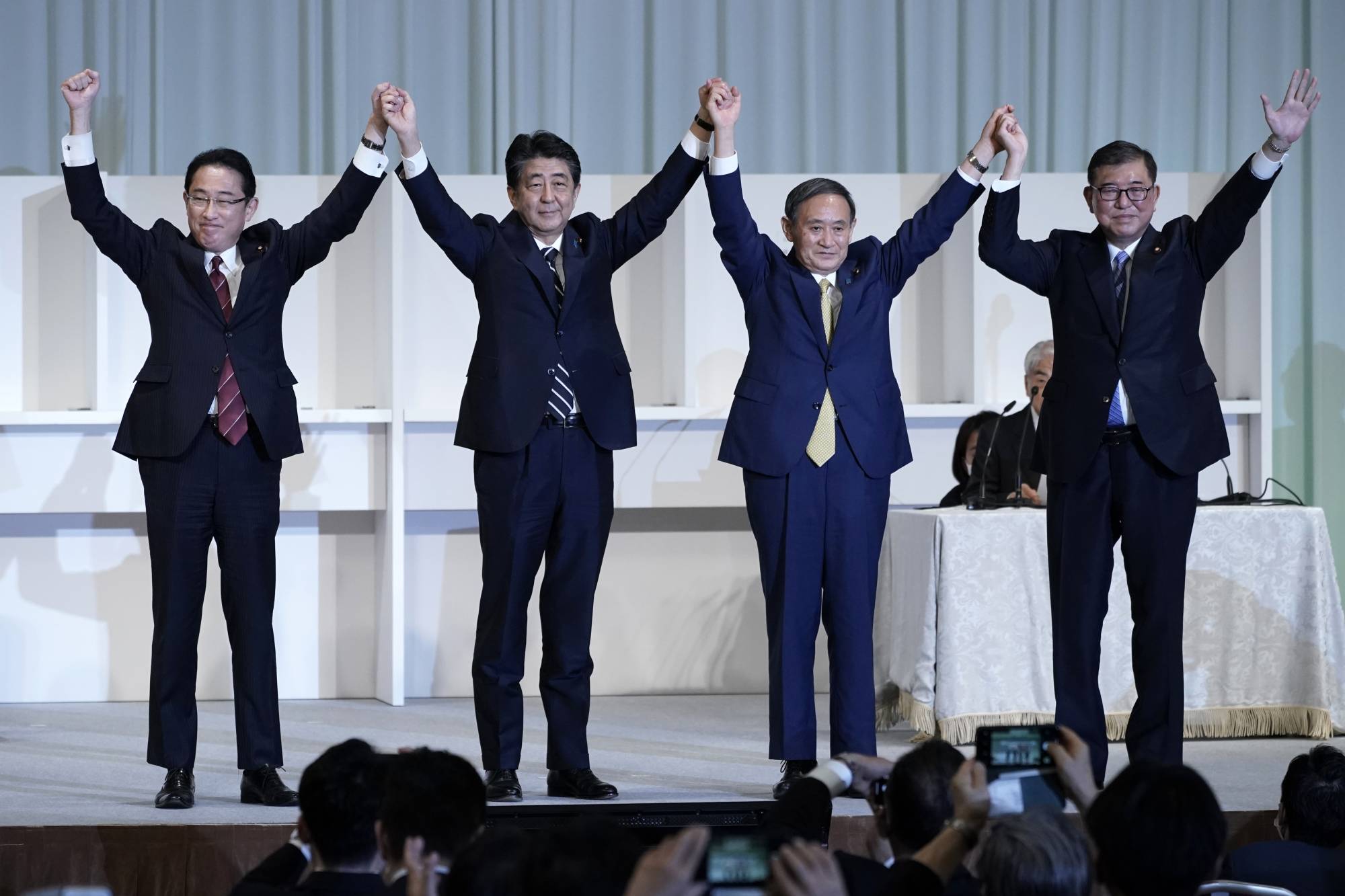 LDP Policy Research Council Chairman Fumio Kishida (from left to right), Prime Minister Shinzo Abe, chief Cabinet secretary Yoshihide Suga and LDP lawmaker Shigeru Ishiba acknowledge the crowd during the party's leadership election in Tokyo on Monday. | AP