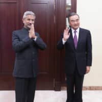 Indian External Affairs Minister Subrahmanyam Jaishankar (left) and Chinese Foreign Minister Wang Yi pose for a photo as they meet in Moscow last Thursday.  | XINHUA / VIA AP