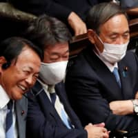 Remarks by Cabinet ministers, including Finance Minister Taro Aso (left), have added fuel to speculation about an early election. | REUTERS