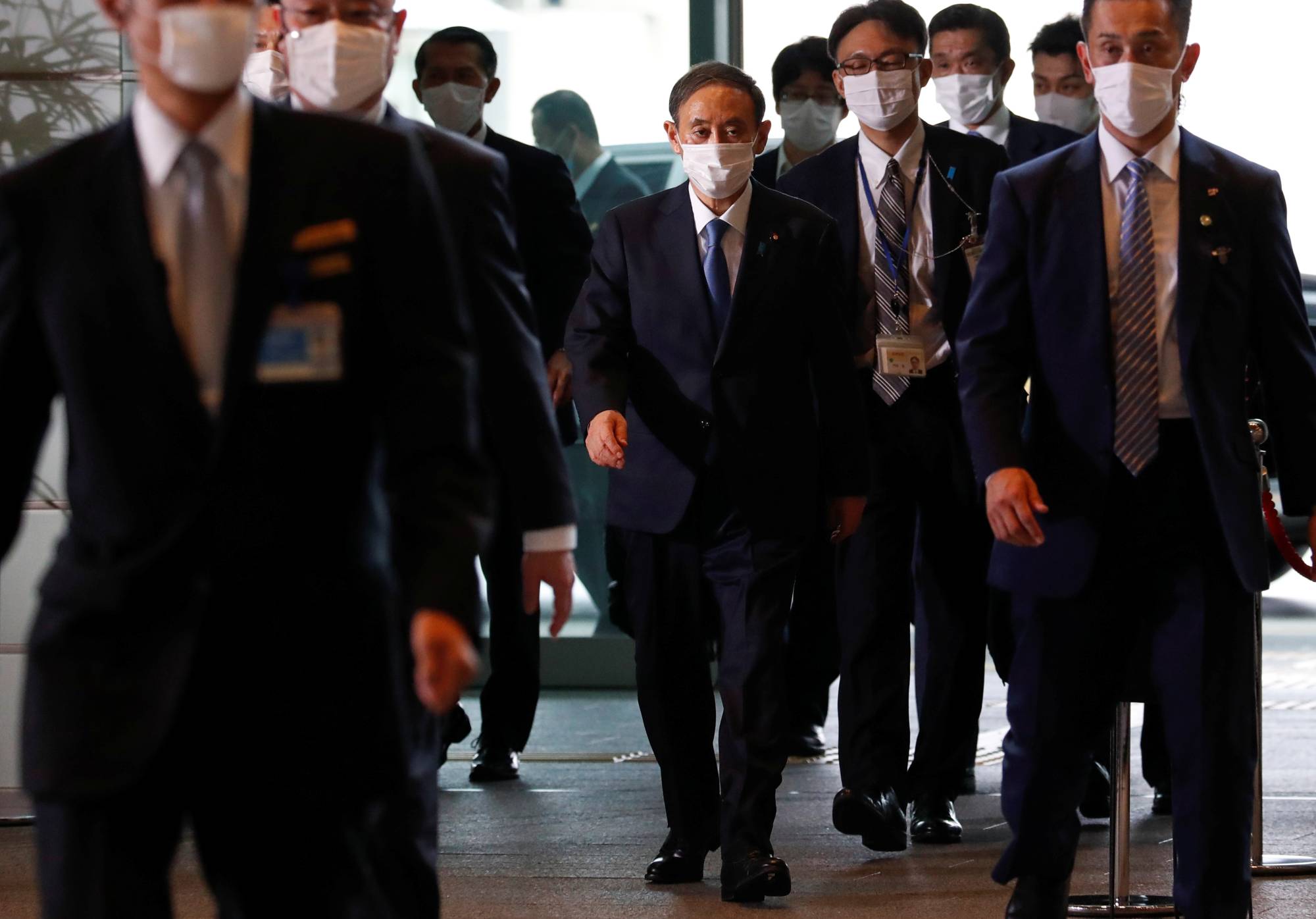 Newly elected Prime Minister Yoshihide Suga arrives at the Prime Minister's Office in Tokyo on Wednesday. | REUTERS