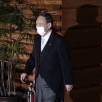 Yoshihide Suga leaves his official residence for the Imperial Palace to attend the attestation ceremony of his new Cabinet on Wednesday in Tokyo. | AP