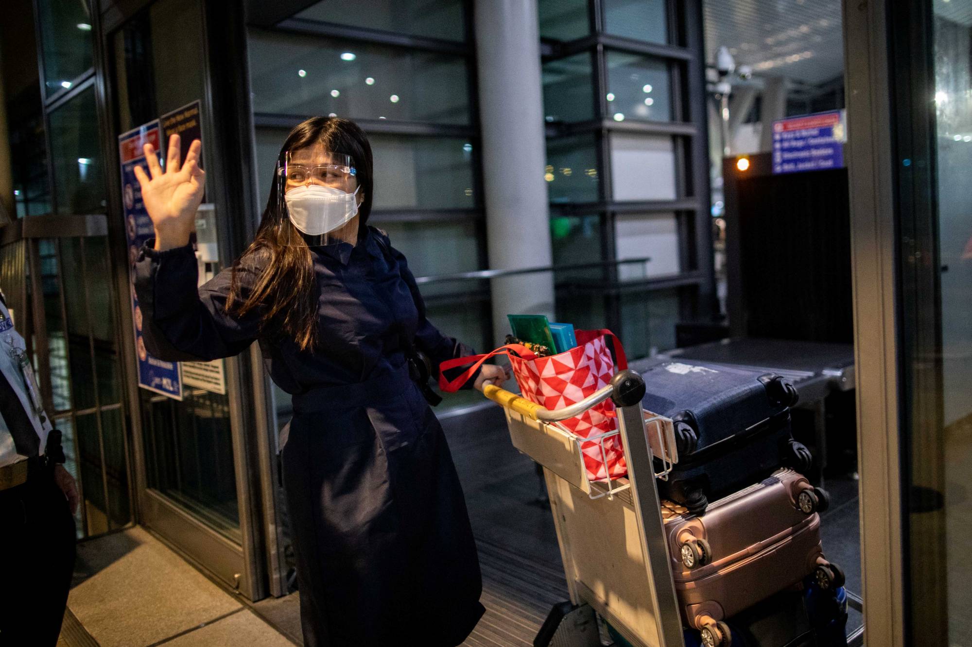Filipino nurse April Glory waves to her family before leaving for the U.K. in August after the government partially eased restrictions on health workers' movements.  | REUTERS 