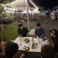 People hang out at a public space in Tokyo\'s Shimokitazawa neighborhood.  | AP