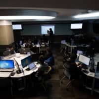 Students sit at computers during a cyberdefense programming class in the \"War Room\" at Korea University in Seoul in November 2015. | BLOOMBERG