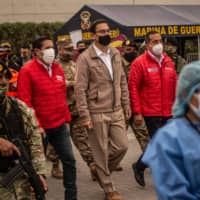 Peru\'s president, Martin Vizcarra (center), who\'s national economy is one of the worst performing globally amid the COVID-19 pandemic, oversees the distribution of supplies to those in need on the outskirts of Lima on Tuesday. | AFP-JIJI