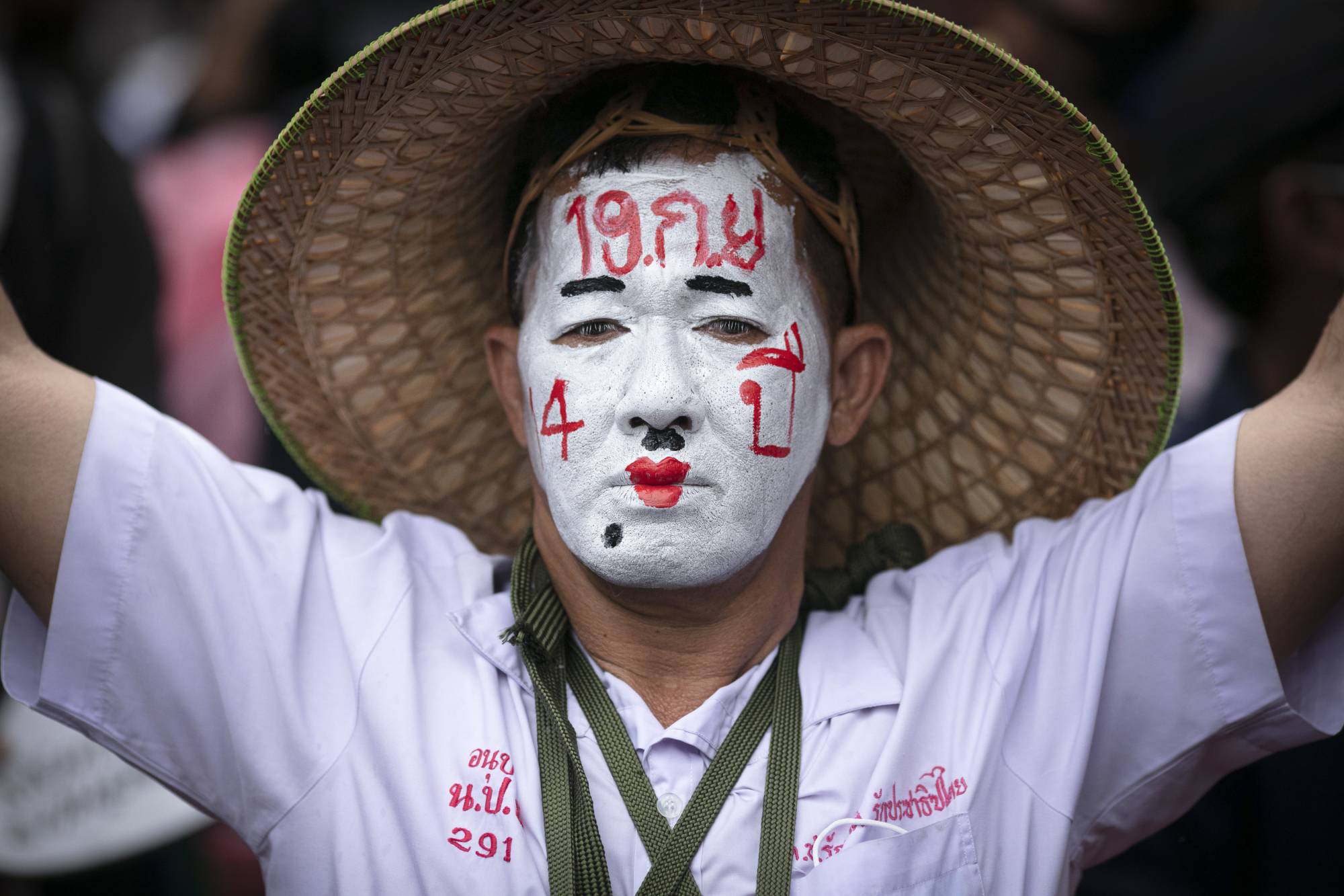 A pro-democracy protester with a painted face reading 'Sept. 19 Coup' protests at the Thammasat University in Bangkok on Saturday. | AP