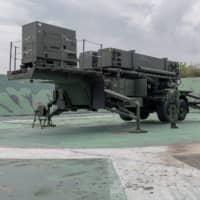 Soldiers are seen near military equipment at a Taiwanese air defense missile base. | TAIWAN PRESIDENTIAL OFFICE / VIA REUTERS