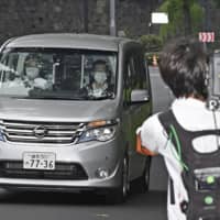 A police vehicle carrying Tatsuya Yamaguchi, a former member of all-male pop idol group Tokio, arrives at the Metropolitan Police Department\'s headquarters in Tokyo on Tuesday afternoon. | KYODO