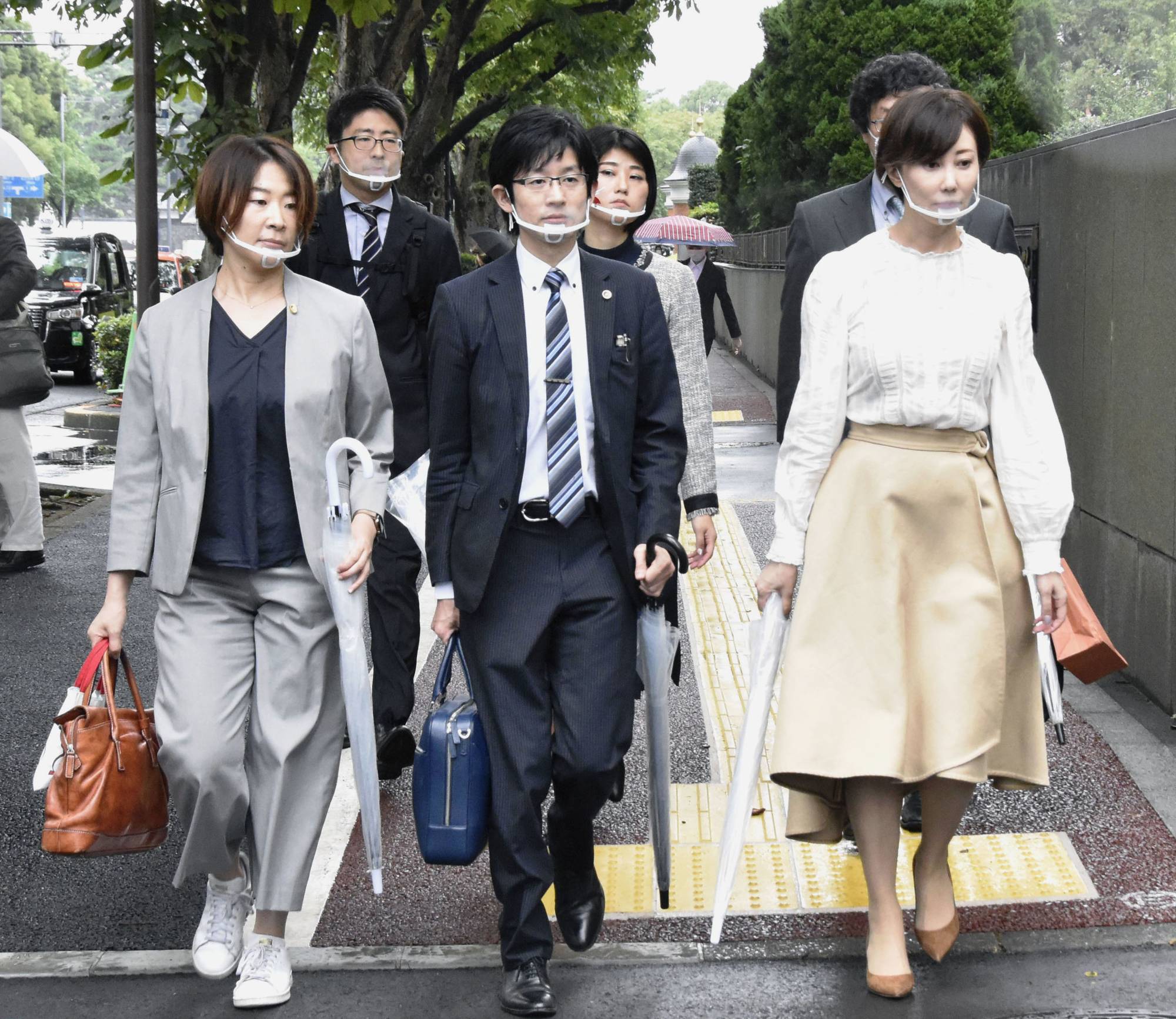 A group of lawyers representing a sex business operator walk to the Tokyo District Court on Wednesday, to sue the state over its blanket exclusion of the sex industry from a cash handout program amid the coronavirus pandemic.  | KYODO